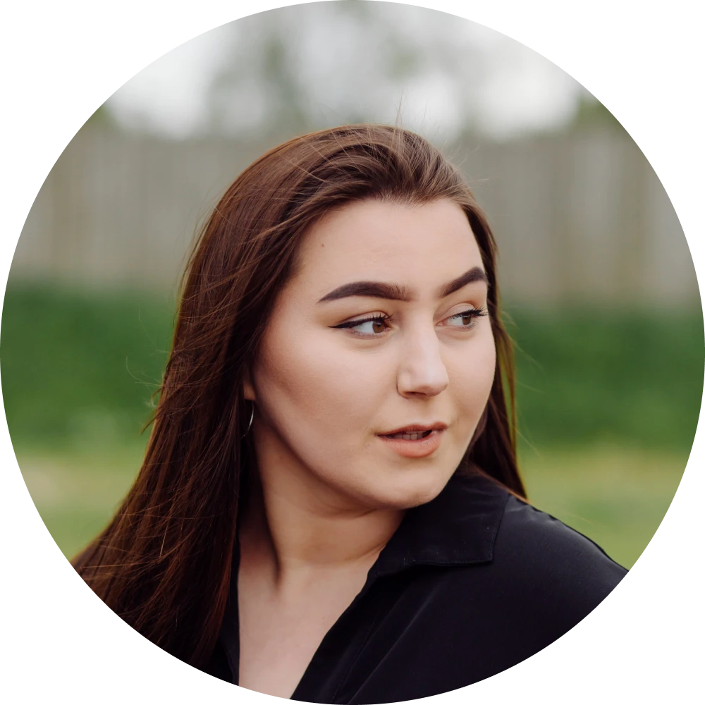 Woman with long brown hair outdoors.
